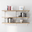 3 tier decorative shelves with white adjustable brackets with books and decor items against a white wall