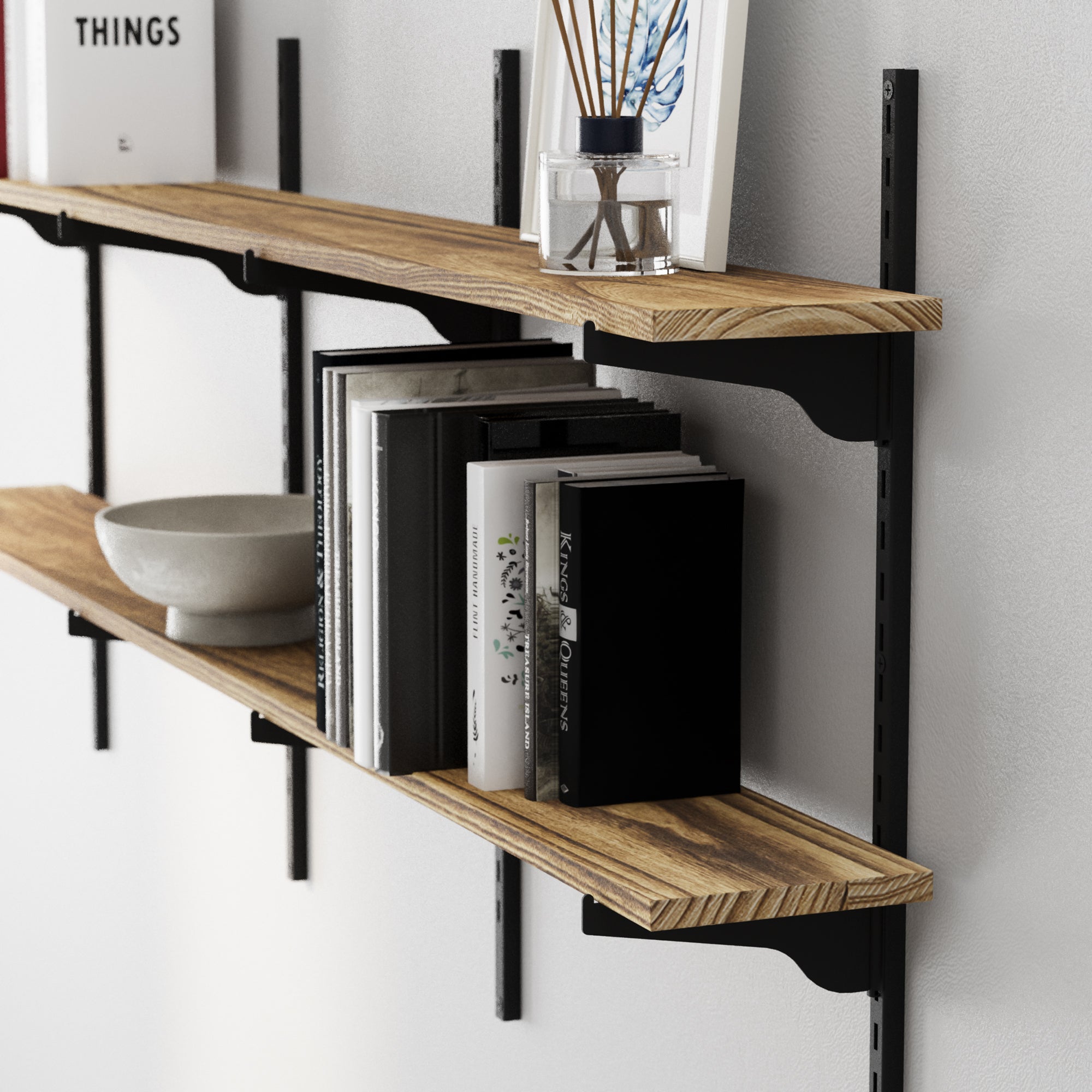 Wooden book shelves with adjustable black brackets holding books and decor items against a white wall