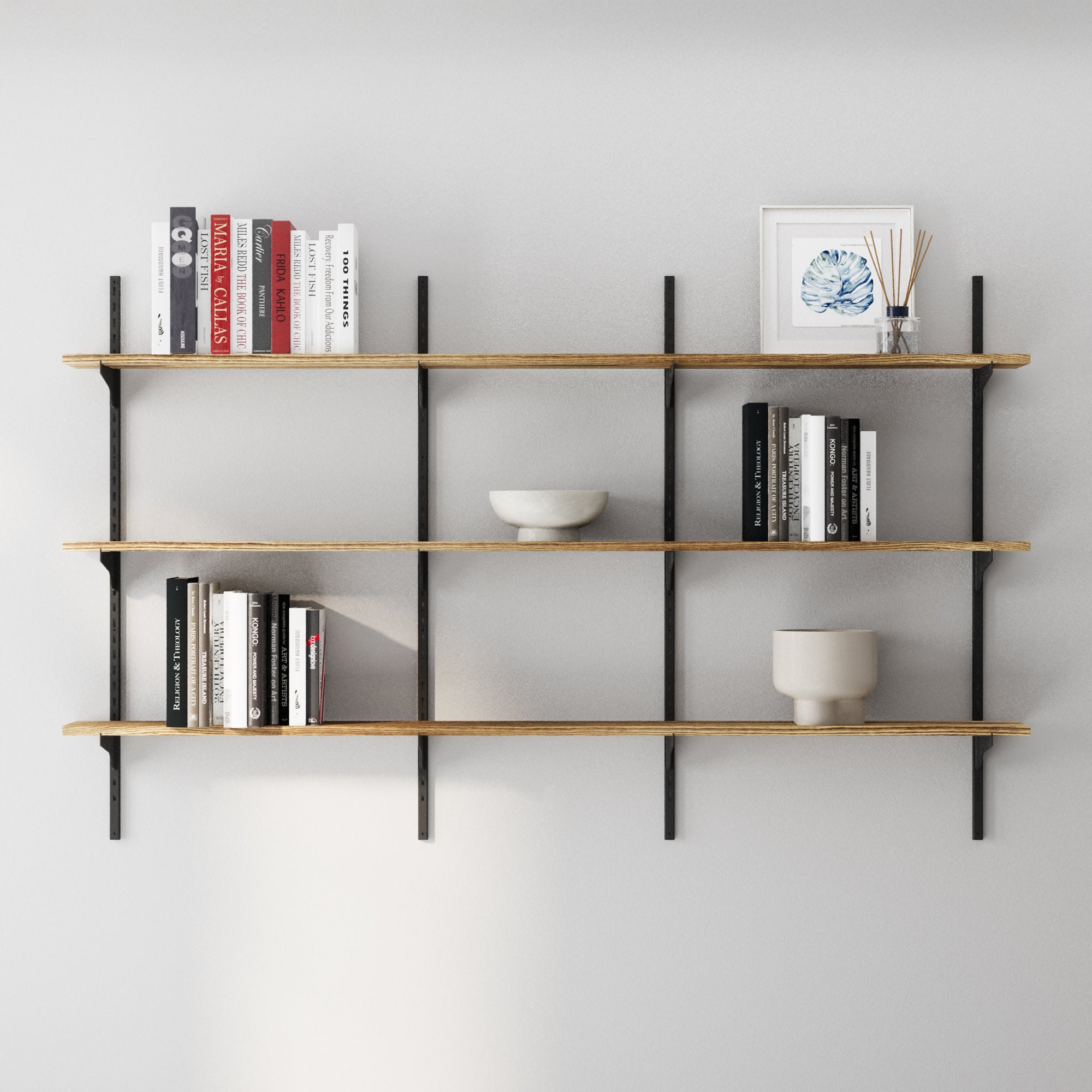 3 tier wood shelves with books and decor items against a gray wall