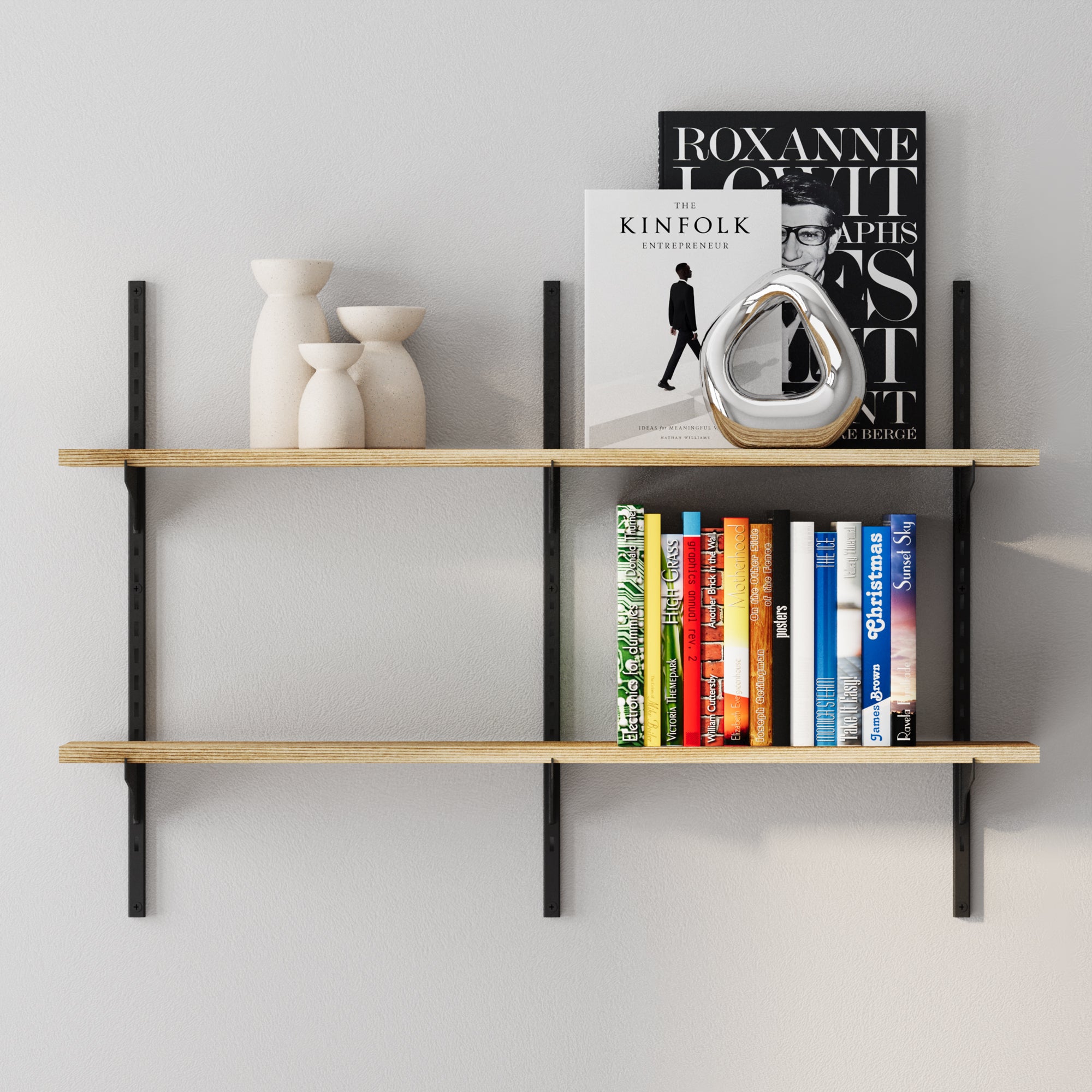 Two-tier adjustable floating wall shelf with black metal rails and light wood boards styled with books, decorative vases, and a chrome accent piece.