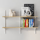 Wooden shelving unit with books and decorative items against a light gray wall
