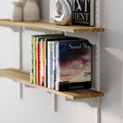 Multi tier floating shelves with books and decorative items against a white wall