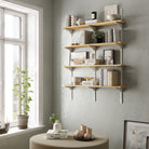 Wall-mounted shelving unit with books, plants, and decor items in a beautiful living room setup with a window.