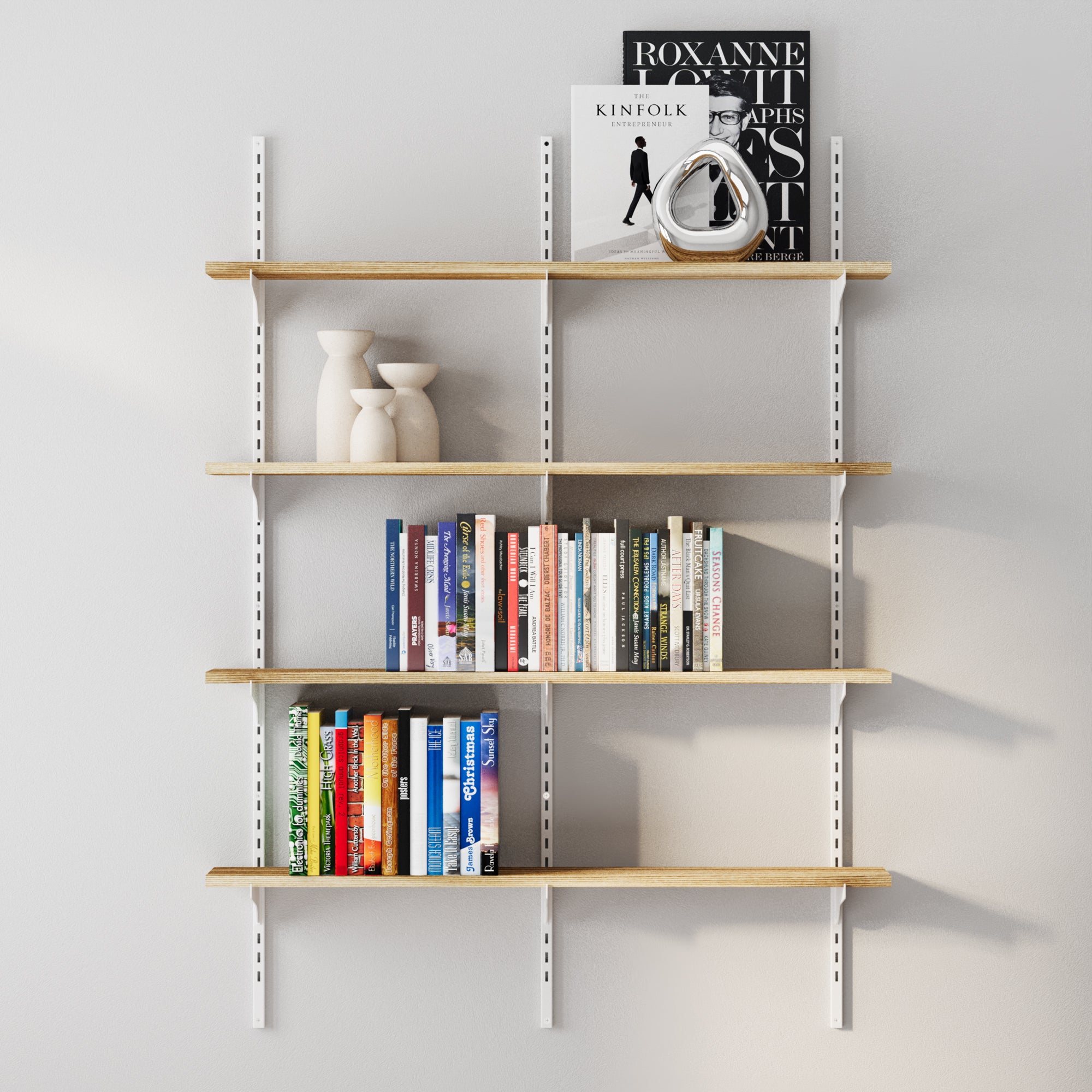 4 tier office shelving unit with books and decor items on a plain wall.
