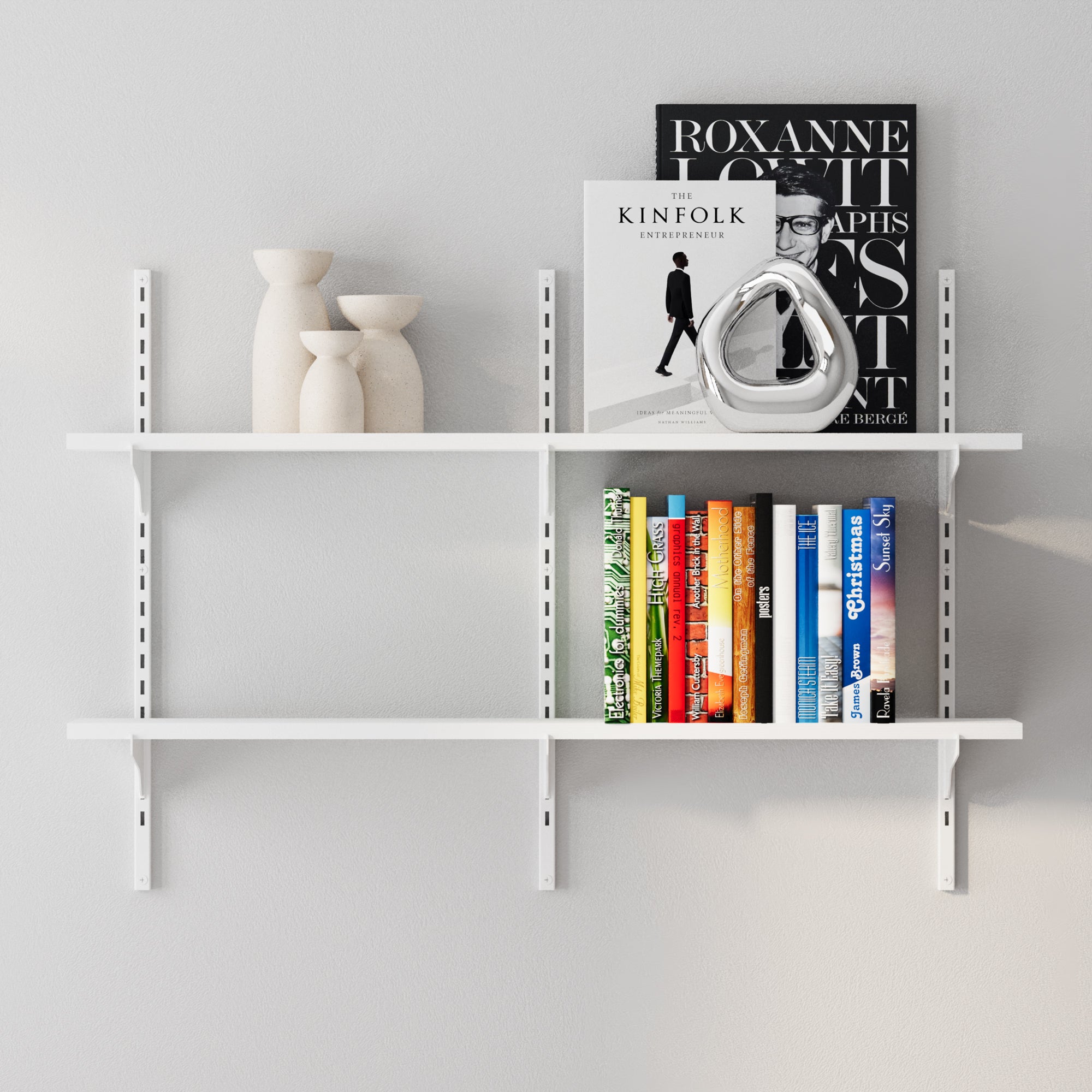 White wall-mounted shelf with books, decorative items, and a poster on a light gray background
