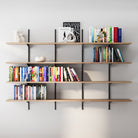 4 tier adjustable shelf with black heavy duty metal brackets and rails with books and decorative items against a gray wall