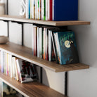 Storage shelving system with books, including a 'Peter Pan' book, against a neutral wall.