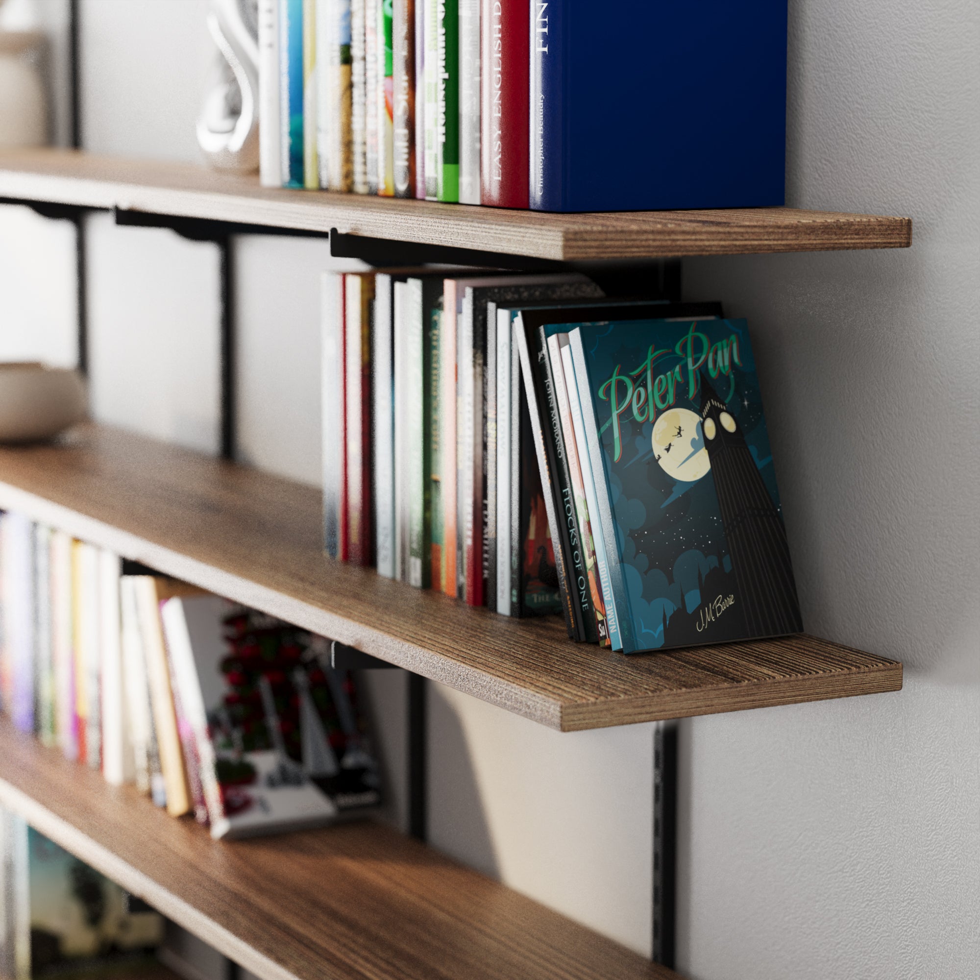 Storage shelving system with books, including a 'Peter Pan' book, against a neutral wall.