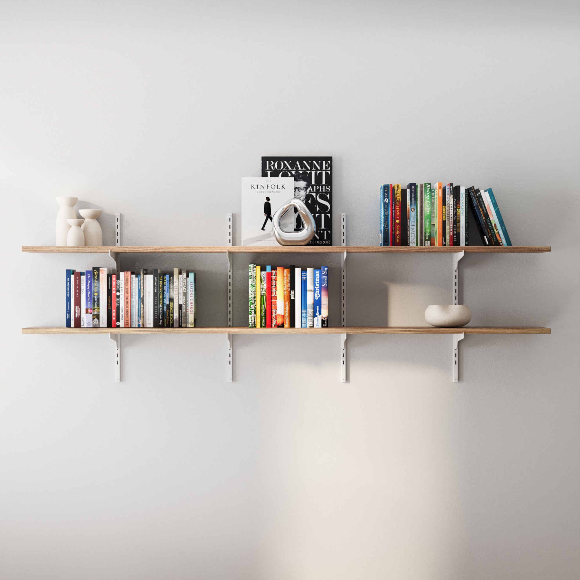 2 tier wooden shelves with books and decor items against a white wall