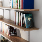 72 inch long and 10 inch deep adjustable shelves with books and a 'Peter Pan' book on a white wall