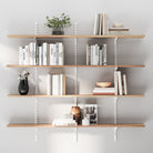 4 tier Scandinavian shelves with books and decorative items against a white wall
