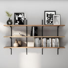 3 tier versatile shelving unit with books, decorative items, and framed pictures against a gray wall.