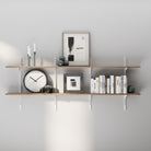 2 tiered adjustable wall shelf with decorative items against a gray wall