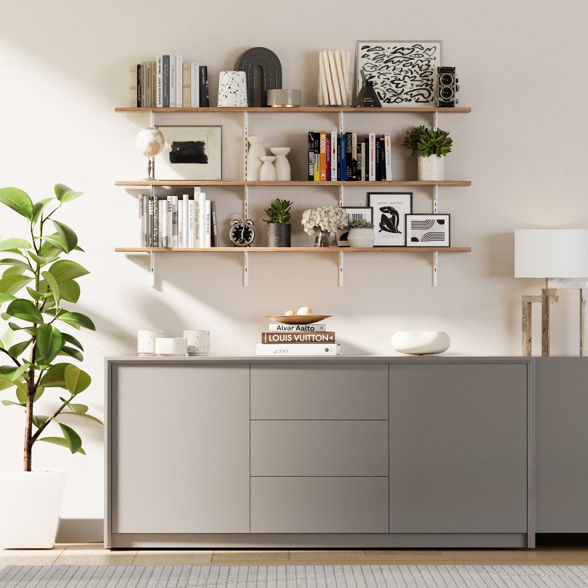 Modern living room with 3 tiered living room storage shelving unit, books, and decor items against a white wall.