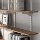 Heavy duty bracket shelf with books and a picture frame against a gray wall