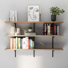 Modern wall display with three floating shelves in black metal and wood finish, styled with books, decor pieces, framed artwork, and greenery for a clean interior look.