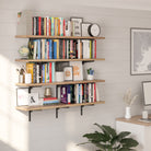 Styled home office setup featuring a 4-tier wall book shelf filled with books, decor, framed prints, and a clock against a light shiplap wall.