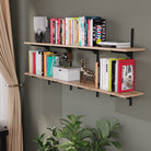 Floating shelf for living room decor with books and decorative items against a gray wall.