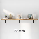 A minimalistic 72 inch long floating shelf mounted on a white wall, holding books, a plant, a vase, and decorative items, demonstrating a clean and modern storage solution.