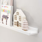 White toddler shelf styled with a children's book titled "My First Animals," a small wooden house-shaped decorative item, and a wooden toy tree. This setup illustrates how the wood shelf can be used to organize and display items, offering both functionality and a stylish look, particularly in nurseries or children's rooms.